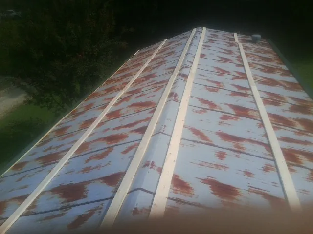 Rusted metal roof panels with new wood purlins before replacement — Storm Damage Roof Repair in Glenwood by Roofing Brothers